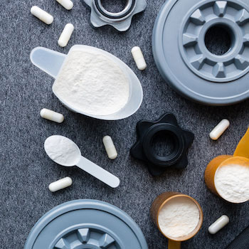 Creatine supplement powder in scoops, pills, and weight plates