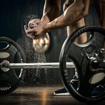 Weight lifter getting ready to lift barbell with heavy weights